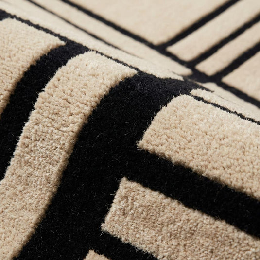 Translation missing: es.Close-up of hand tufted wool rug texture showing dense cut pile wool fibers and crisp black geometric line pattern on cream background
