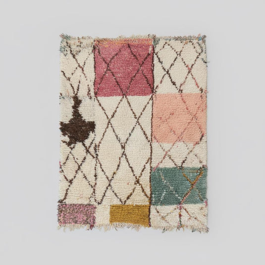 Translation missing: es.Boho Berber-inspired area rug with warm tones, diamonds, and blocks styled with a mid-century chair