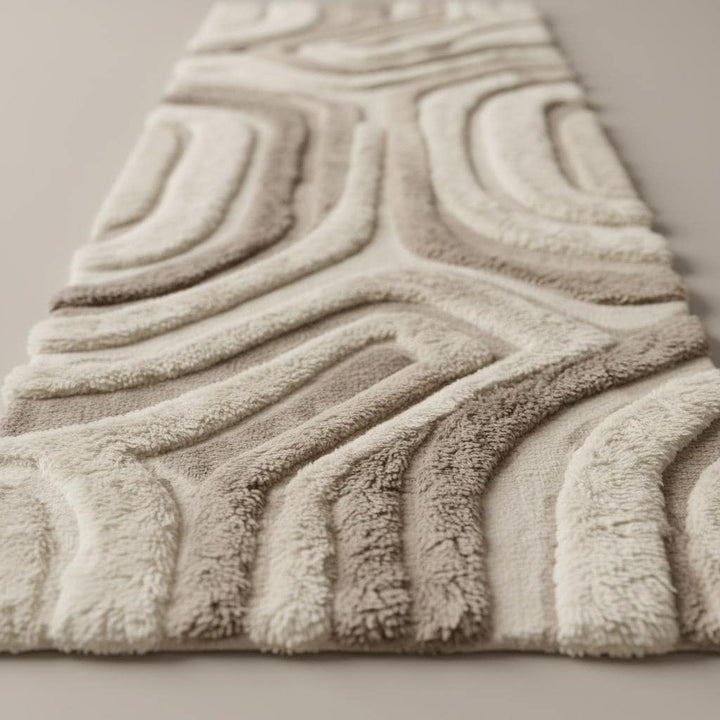 Translation missing: es.Close-up of plush hand tufted runner rug showing dense cut pile texture, sculpted abstract curves, and soft ivory beige wool fibers