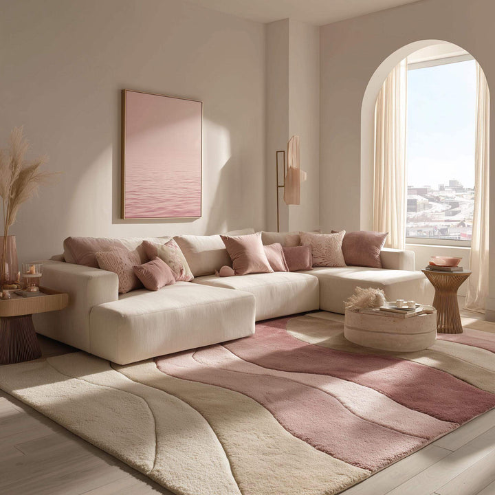 Translation missing: es.Blush pink wave pattern area rug placed under cream sectional sofa in modern living room décor
