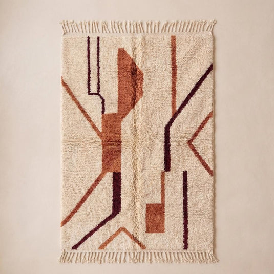 Translation missing: es.Plush textured ivory rug with geometric tribal pattern and fringe edge