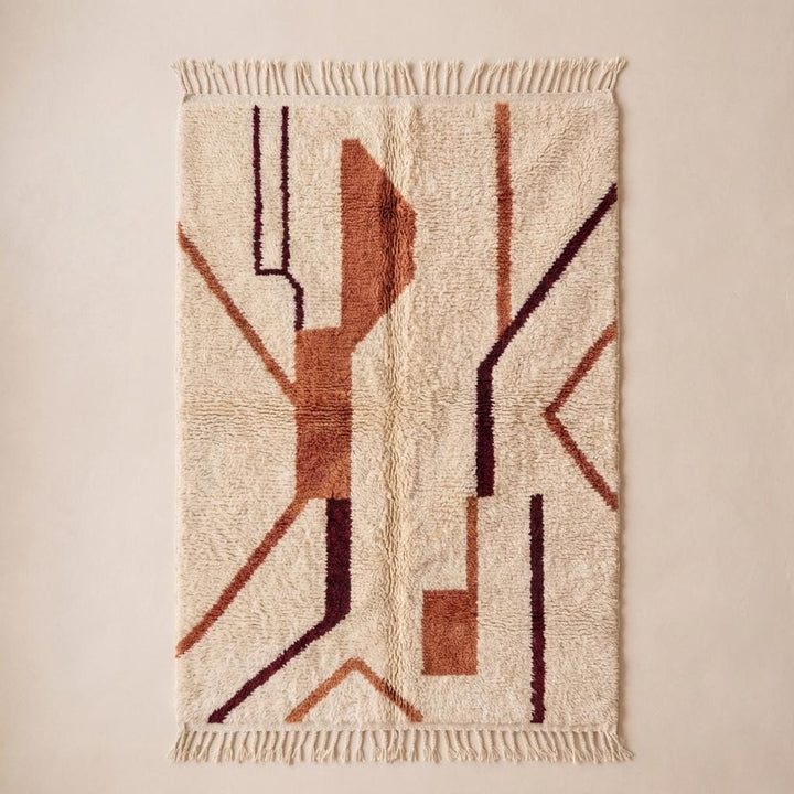 Translation missing: es.Plush textured ivory rug with geometric tribal pattern and fringe edge