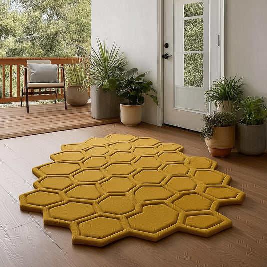 Translation missing: es.Mustard honeycomb rug with sculpted hexagon pattern on wooden floor by a glass door