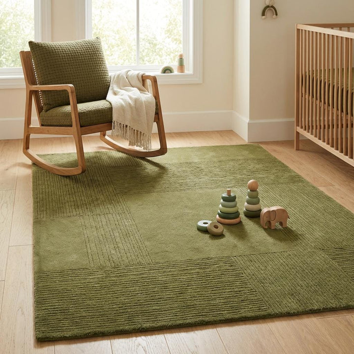 Translation missing: en.Soft olive green geometric area rug styled in cozy nursery with crib and neutral decor creating warm calming atmosphere