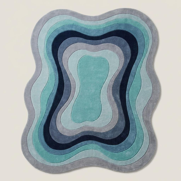 Translation missing: es.Contemporary irregular area rug in layered blue and teal shades placed beside a mid century modern accent chair __etsy:8006148360