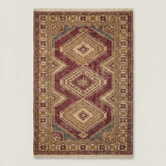 Translation missing: en.Traditional Oushak geometric rug styled in a neutral living room with stone flooring and wooden furniture