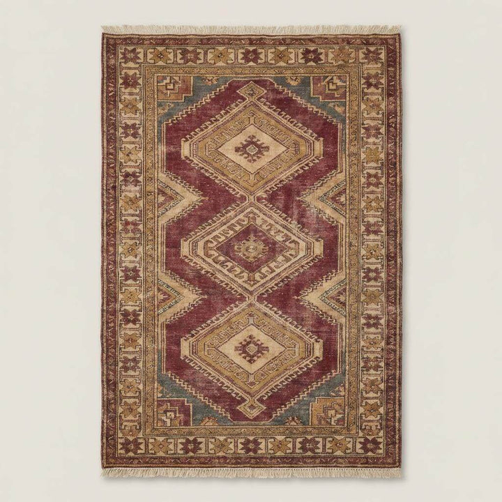 Translation missing: es.Traditional Oushak geometric rug styled in a neutral living room with stone flooring and wooden furniture