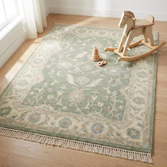 Translation missing: es.Green wool area rug styled on dark wood floor with neutral furniture and soft lighting