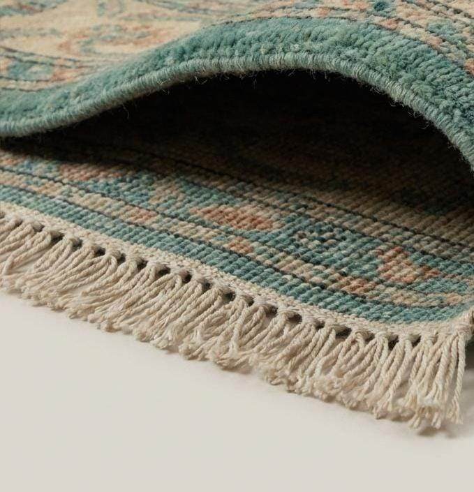 Translation missing: en.Close-up of hand knotted wool pile showing dense knot structure and natural fiber texture