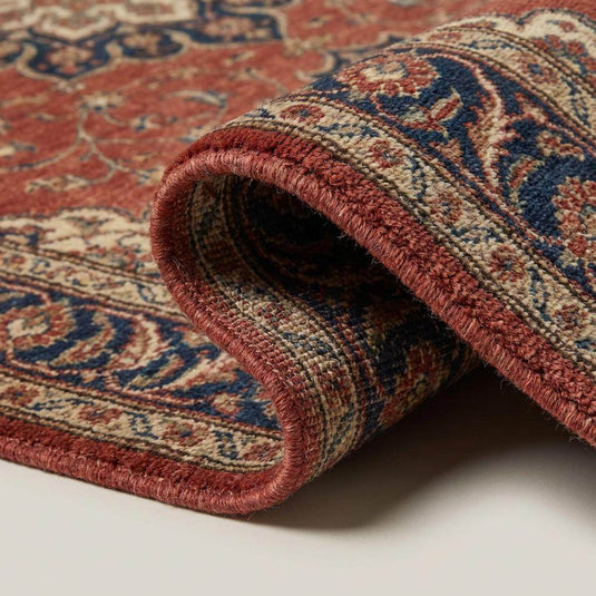 Translation missing: es.Close-up of hand-knotted wool pile showing dense knot structure and natural fiber variation in rust, cream, and indigo blue yarns
