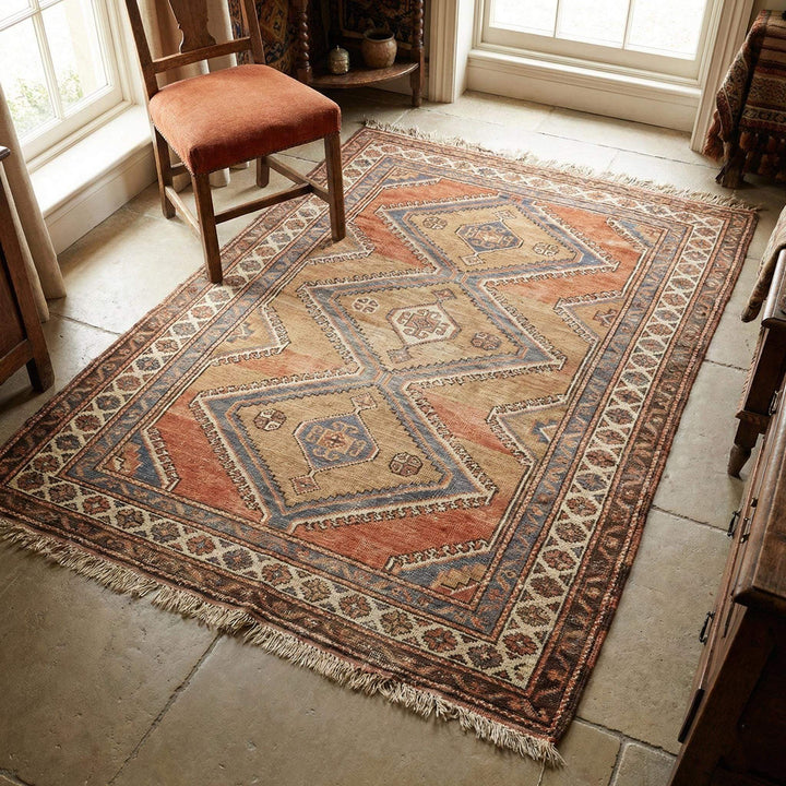 Translation missing: es.Tribal geometric hand knotted wool area rug with warm rust and sand tones on wooden floor
