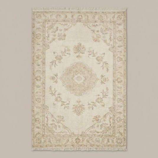 Translation missing: es.Neutral hand knotted area rug styled in a bright bedroom with wooden floors and soft natural light