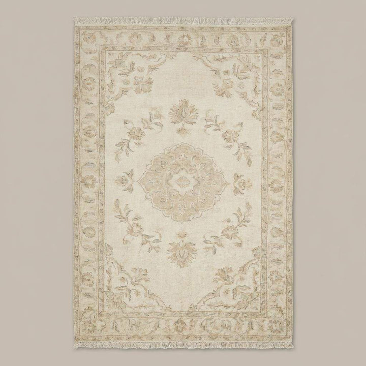 Translation missing: es.Neutral hand knotted area rug styled in a bright bedroom with wooden floors and soft natural light