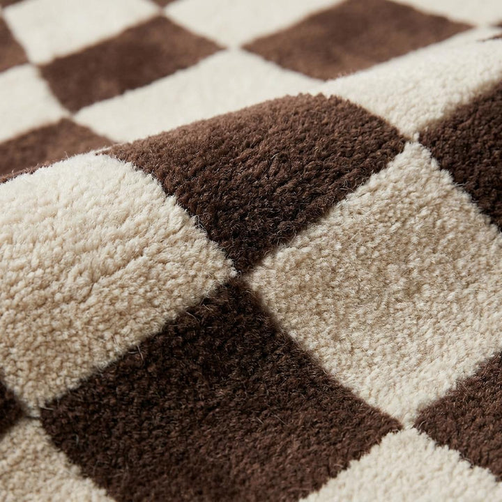 Translation missing: es.Close-up texture of plush hand-tufted wool rug showing soft cut pile and sculpted checkerboard pattern in brown and cream __etsy:8074304171
