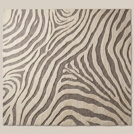Translation missing: es.Modern ivory and gray wool area rug with sculpted abstract pattern on hardwood floor