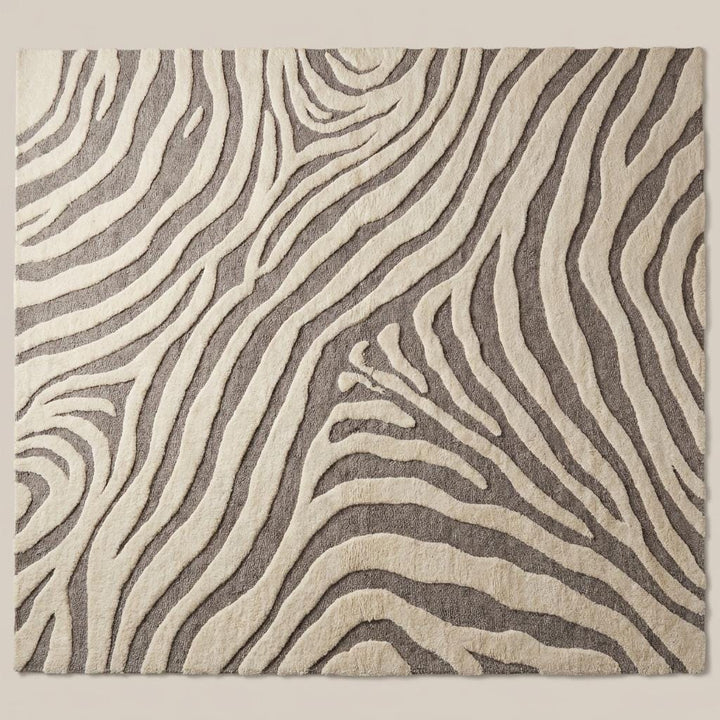 Translation missing: es.Modern ivory and gray wool area rug with sculpted abstract pattern on hardwood floor