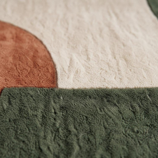 Translation missing: en.Close view of abstract tufted rug with soft textured surface featuring bold shapes in warm modern organic colors