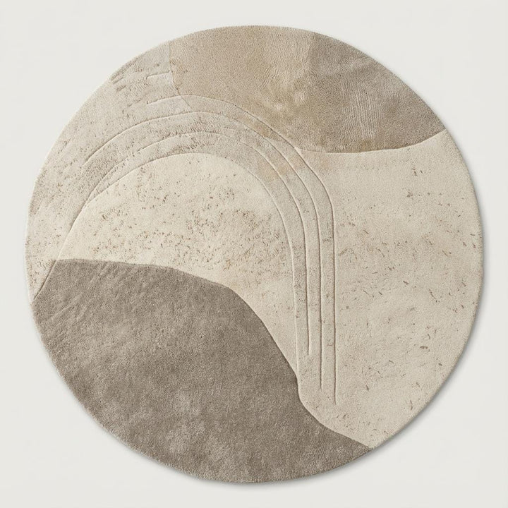 Translation missing: es.Hand-tufted circular wool rug featuring carved textured patterns on light wood flooring in a modern Scandinavian interior
