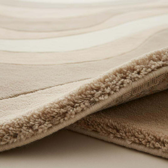 Translation missing: es.Beige cream area rug with wavy pattern in minimalist living room setting