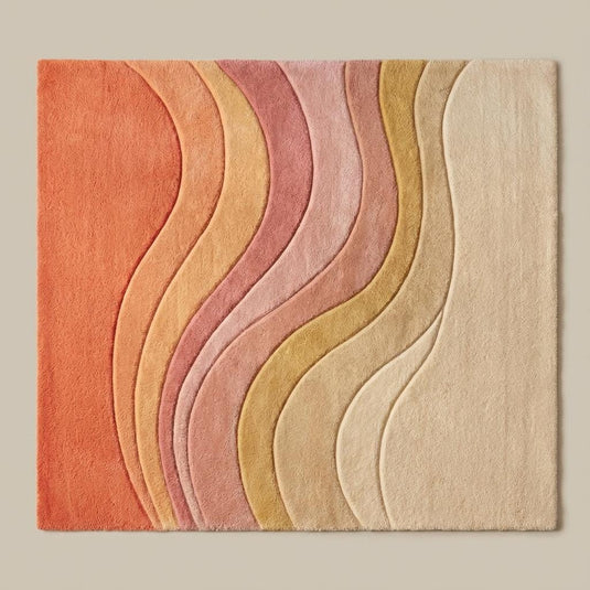 Translation missing: es.Hand-tufted wool area rug featuring carved wave patterns in peach, pink, gold, and cream tones on hardwood flooring