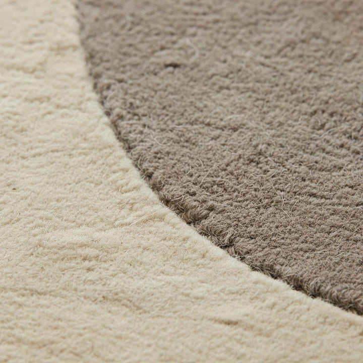 Translation missing: es.Close-up view of abstract neutral rug texture highlighting soft woven fibers, plush surface, and clean craftsmanship, showing the quality and comfort of the modern minimalist area rug