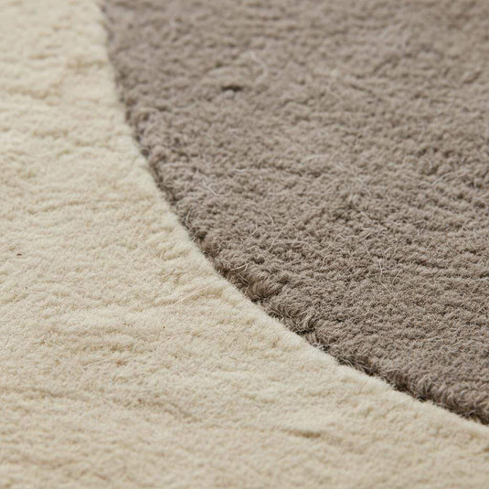 Translation missing: es.Close-up view of abstract neutral rug texture highlighting soft woven fibers, plush surface, and clean craftsmanship, showing the quality and comfort of the modern minimalist area rug