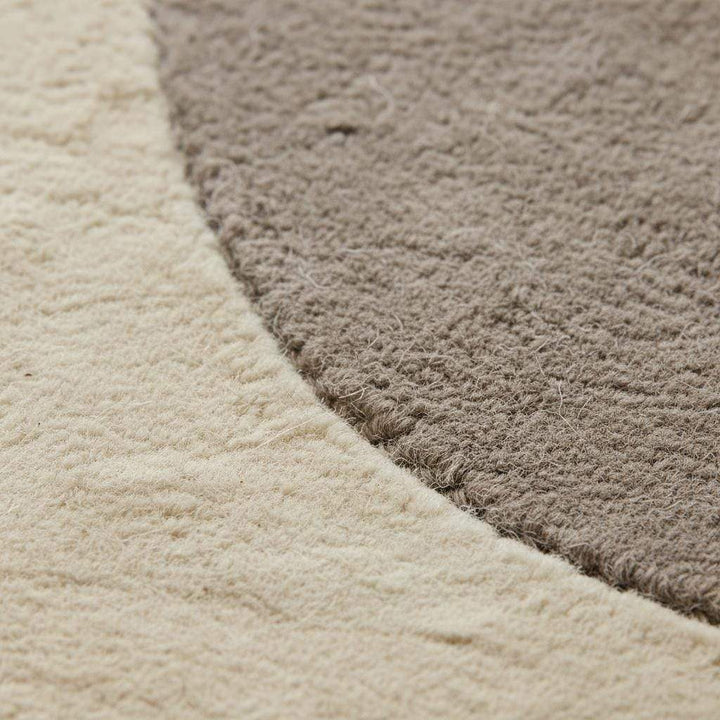 Translation missing: es.Close-up view of abstract neutral rug texture highlighting soft woven fibers, plush surface, and clean craftsmanship, showing the quality and comfort of the modern minimalist area rug