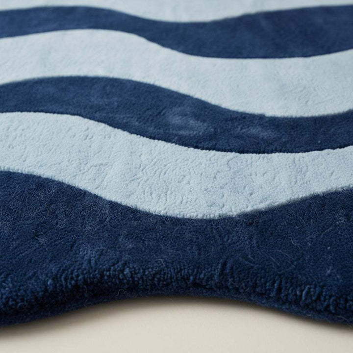 Translation missing: en.Irregular shaped curvy area rug in deep blue tones on hardwood floor, adding modern artistic style to living space
