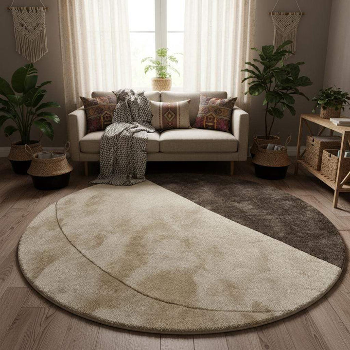 Translation missing: en.Contemporary circular rug with minimalist geometric design in warm taupe and ivory tones, shown in a modern interior setting