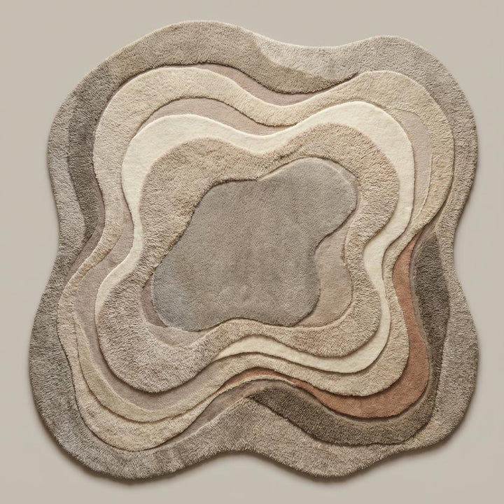 Translation missing: en.Topographic-inspired beige and cream abstract rug with carved contours adding depth and texture to a cozy contemporary seating area