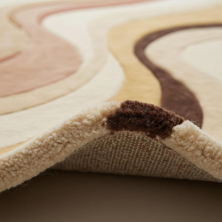 Translation missing: es.Close-up detail of abstract area rug texture showing dense plush fibers, soft pile, smooth weave, and high-quality craftsmanship in warm neutral earth tones