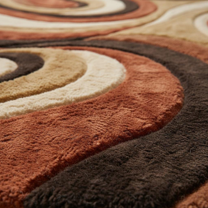 Translation missing: en.Close-up of plush shag rug texture showing dense high-pile fibers, sculpted abstract swirl pattern, and layered earth tone colors that highlight softness, depth, and quality craftsmanship