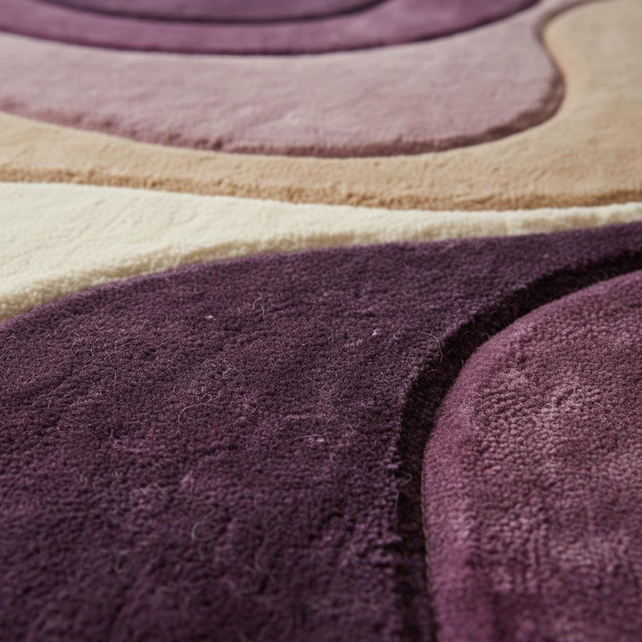 Translation missing: en.Close-up of plush abstract rug texture showing soft dense fibers, smooth pile finish, and layered color transitions in mauve, plum, beige, and cream tones