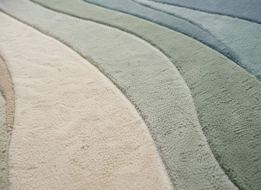 Translation missing: es.Close-up detail of plush abstract rug fibers showing soft texture, dense pile, and smooth craftsmanship in muted blue green and ivory tones